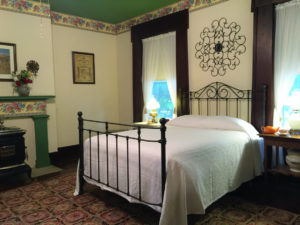 The Hawthorn room, with natural woodwork and an antique bed, is pictured.