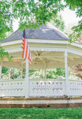 The Old Caledonian's stately gazebo, with green grass and tree boughs, is pictured.