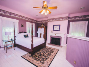 The Heather Room, with a purple color scheme and four post bed, is pictured.