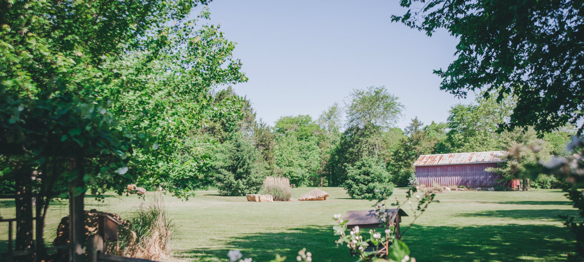 The large backyard of the OCBB with trees and red barn